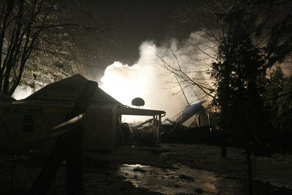 New York plane crash: Firefighters spray foam at the site of a plane crash in Clarence Center.