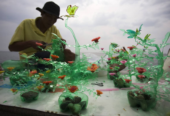 24 hours in pictures: A homeless man creates decorative ornaments resembling plants in Manila.
