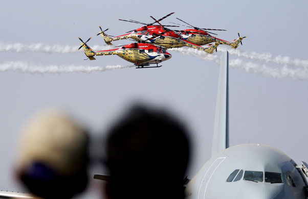 24 hours in pictures: Helicopter aerobatics team fly in formation at the Aero India exhibition.