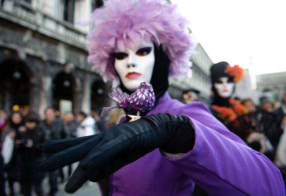 Venice carnival: A woman holds a jewelled bird during carnival festivities in Venice, Italy.