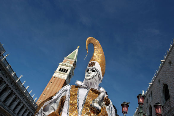 Venice carnival: A costumed person poses on St Mark's square.