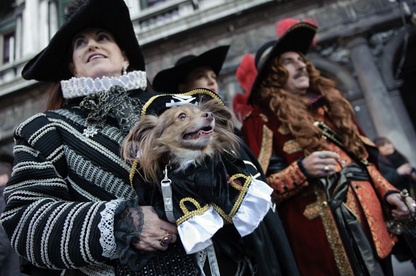 Venice carnival: Costumed revellers pose with a dog.