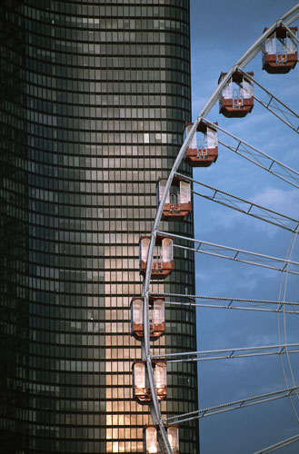 Big wheels : A close-up of a ferris wheel against a skyscraper in Chicago, Illinois.