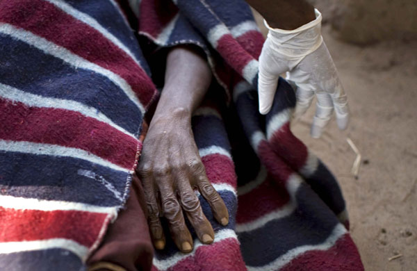 24 hours in pictures: A Red Cross worker covers a the body in northeastern Congo