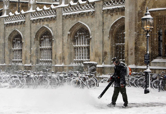 Gallery Snow in England: Cambridge: A man clears snow outside Kings College.