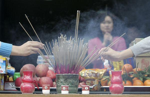 Gallery 24 hours in pictures: Workers place incense sticks after praying in Taipei