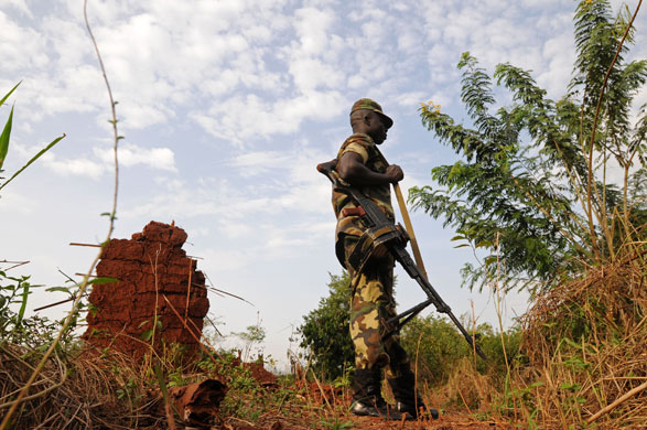 20 February 2009: Democratic Republic of the Congo: A soldier stands outside a destroyed hut
