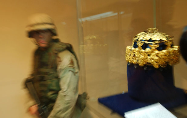 Baghdad museum : a soldier walks in front of a gold crown of Nimrud gold in Baghdad museum 