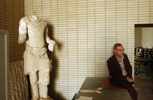 Baghdad museum : Muhsin Hasan sits down beside a destroyed sculpture at the Iraqi Museum