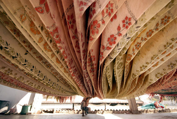 24 hours in pictures: Hyderabad, India: A worker dries saris at a factory  