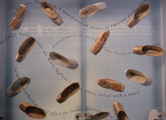 Ballet museum exhibits: A display of pink satin pointe shoes. 