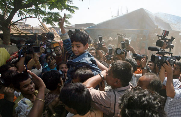 Slumdog children return: People celebrate with Ismail of Slumdog Millionaire .