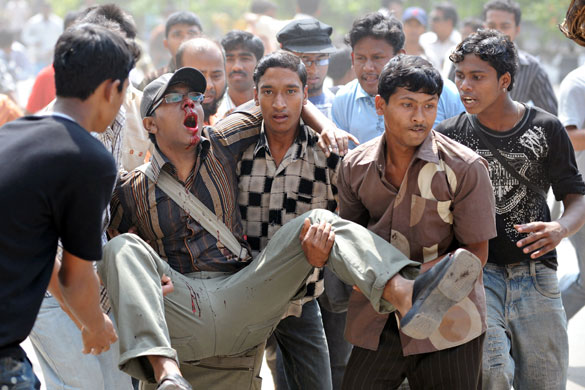 Bangladesh mutiny: An injured Bangladeshi man is carried to safety in Dhaka.