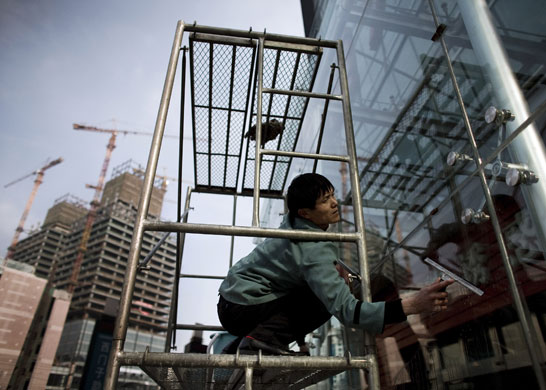 Gallery 3 February 2009: Beijing, China: A worker cleans windows at a office building
