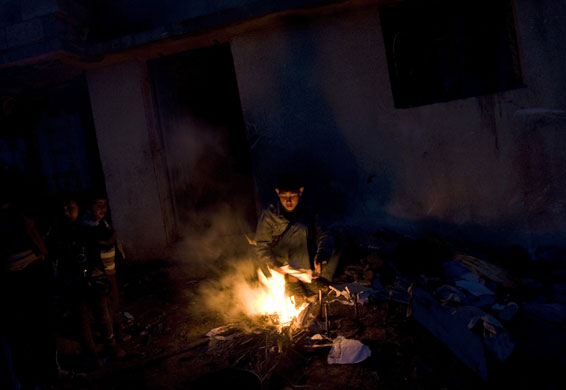 Gallery 24hours in pictures: A Palestinian family keep themselves warm in their damaged house 