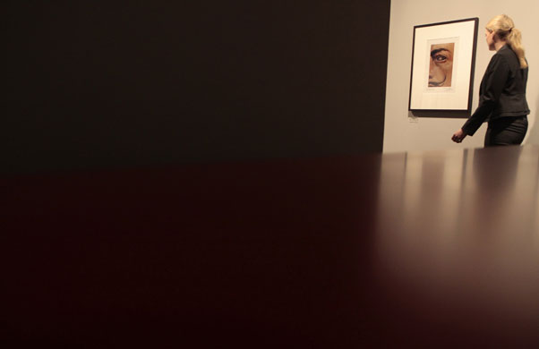 Gallery 24hours in pictures: A woman passes a self-portrait  of the artist Salvador Dali  in Berlin