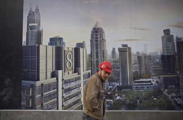Gallery China property market: Chinese builder walks past a hoarding