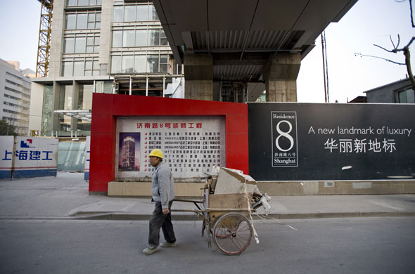 Gallery China property market: A builder walks past a hoarding