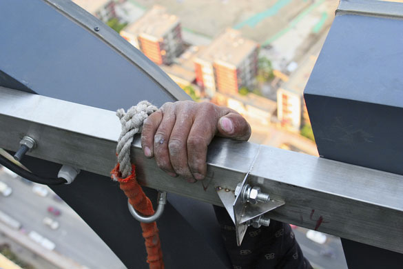 Gallery China property market: onstruction Worker Installing Neon Sign