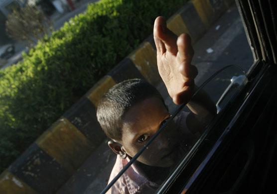 Gallery 24 hours in pictures : A boy begs for alms at a traffic intersection in Mumbai