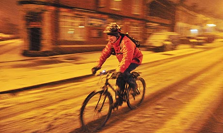 A cyclist braves the early morning roads in Bristol after heavy snow in south-west England