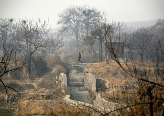 Gallery Severe drought: A farmer walks over a dried-up irrigation canal 