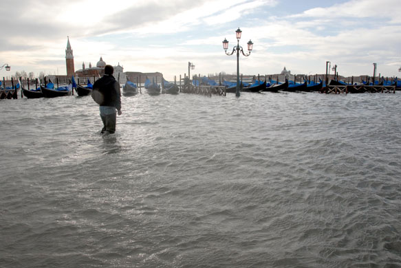 Venice in decline: A man walks on a flooded quay of Venice, Italy in December 2008. 
