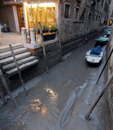 Venice in decline: Boats rest on the bed of an almost dry canal in Venice, Italy.  