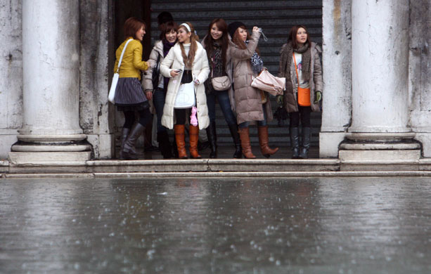 Venice in decline: Tourists avoid a flooded square during a period of high water in Venice.