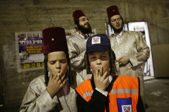 24 hours in pictures: Ultra-Orthodox Jewish youths smoke cigarettes in Jerusalem