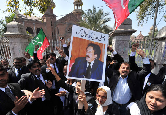 Pakistan lawyers protest: Pakistani lawyers shout slogans as they march with a placard.