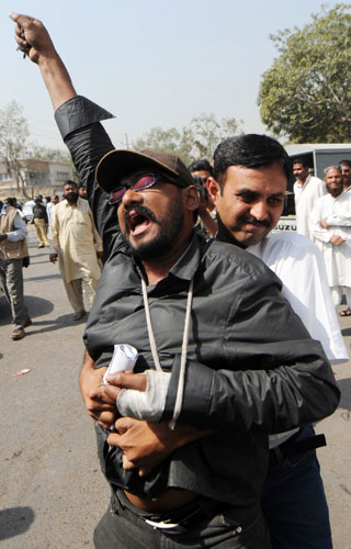 Pakistan lawyers protest: A Pakistani plainclothes policeman arrests a supporter of Jamaat-i-Islami.