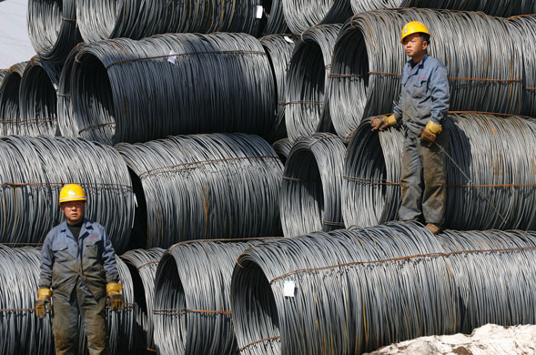 12 March 2009: Shenyang, China:  Workers load steel on a truck at a wholesale market