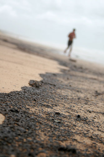 24 hours in pictures: Oil blackens the sand of a beach closed due to an oil slick at Marcoola