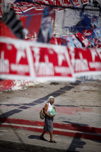 24 hours in pictures: San Salvador, El Salvador: A woman walks past political propaganda