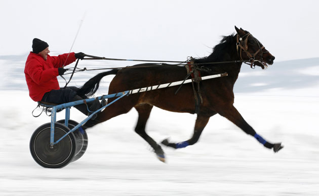 24 hours in pictures: Novosyolovo, Siberia: A trotter competes on the frozen Yenisey river.