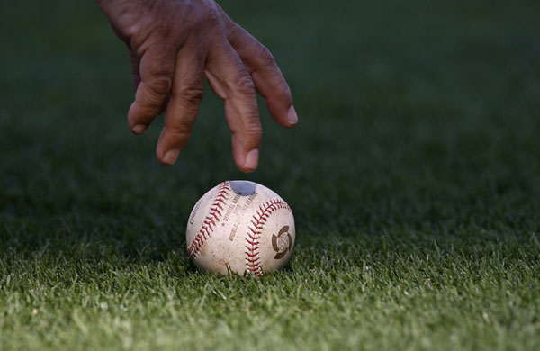 Baseball: An umpire picks up a baseball