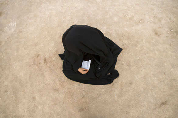 24 hours : A woman prays as she visits a war memorial site near the Iraqi border