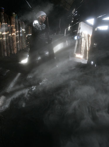 2 March 2009: Kuala Sepetang, Malaysia: A woman works at a charcoal factory