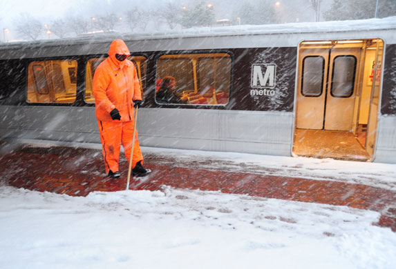 Snowstorm in US: An employee keeps the platform clear at a Metro train station in Vienna