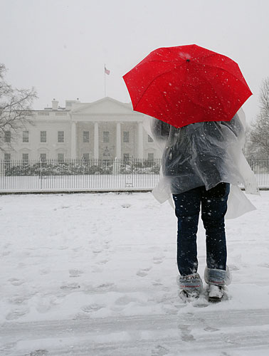 Snowstorm in US: A tourist stops to look at the White House
