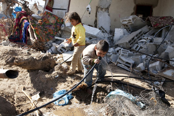Christian Aid on water: World Water Day: Children drinking water from underground pipes, Gaza Strip