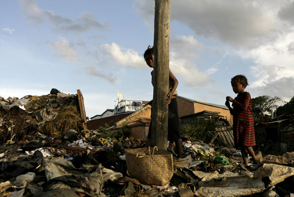 20 March 2009: Antananarivo, Madagascar: A homeless collects strap material from a dump
