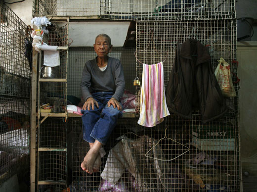20 March 2009: Hong Kong, China: A resident takes a nap at a cage home