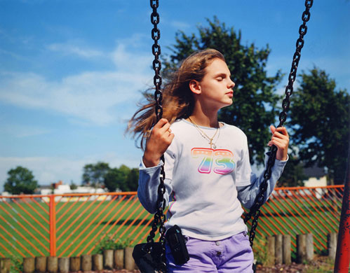 Young Carers: A girl on a swing is lost in a peaceful moment