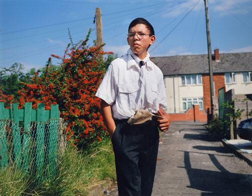 Young Carers: A boy stands in his scout uniform outside