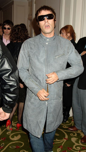 Liam Gallagher fashion: Liam in grey trenchcoat, wearing aviator shades