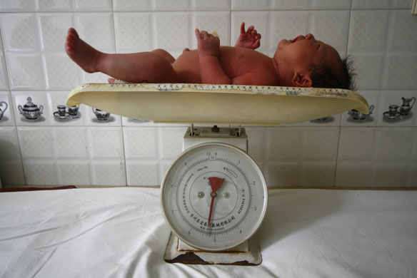 24 hours: A baby cries while being weighed on scales at a local hospital  in China 