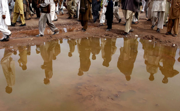 26 March 2009: Nowshera, Pakistan: Displaced people attend a mass prayer