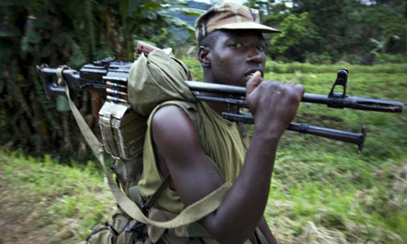 A Rwandan soldier carries his weapon through the village of Pinga in eastern Congo